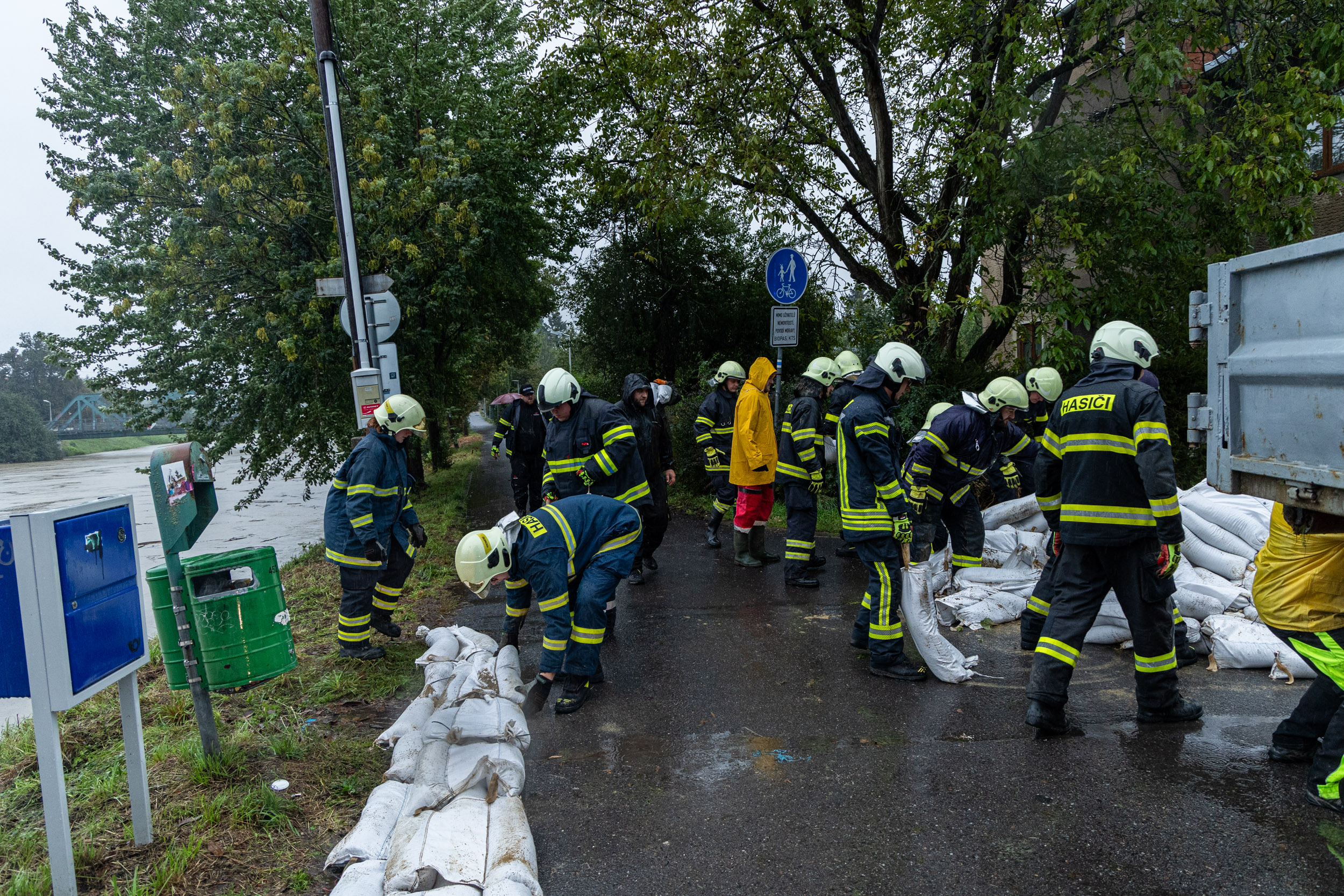 Hasiči budují hráz z pytlů s pískem na Erbenově nábřeží.